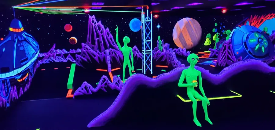 Neon green aliens and spacecraft in the outer space world at Imagine 3D Mini Golf